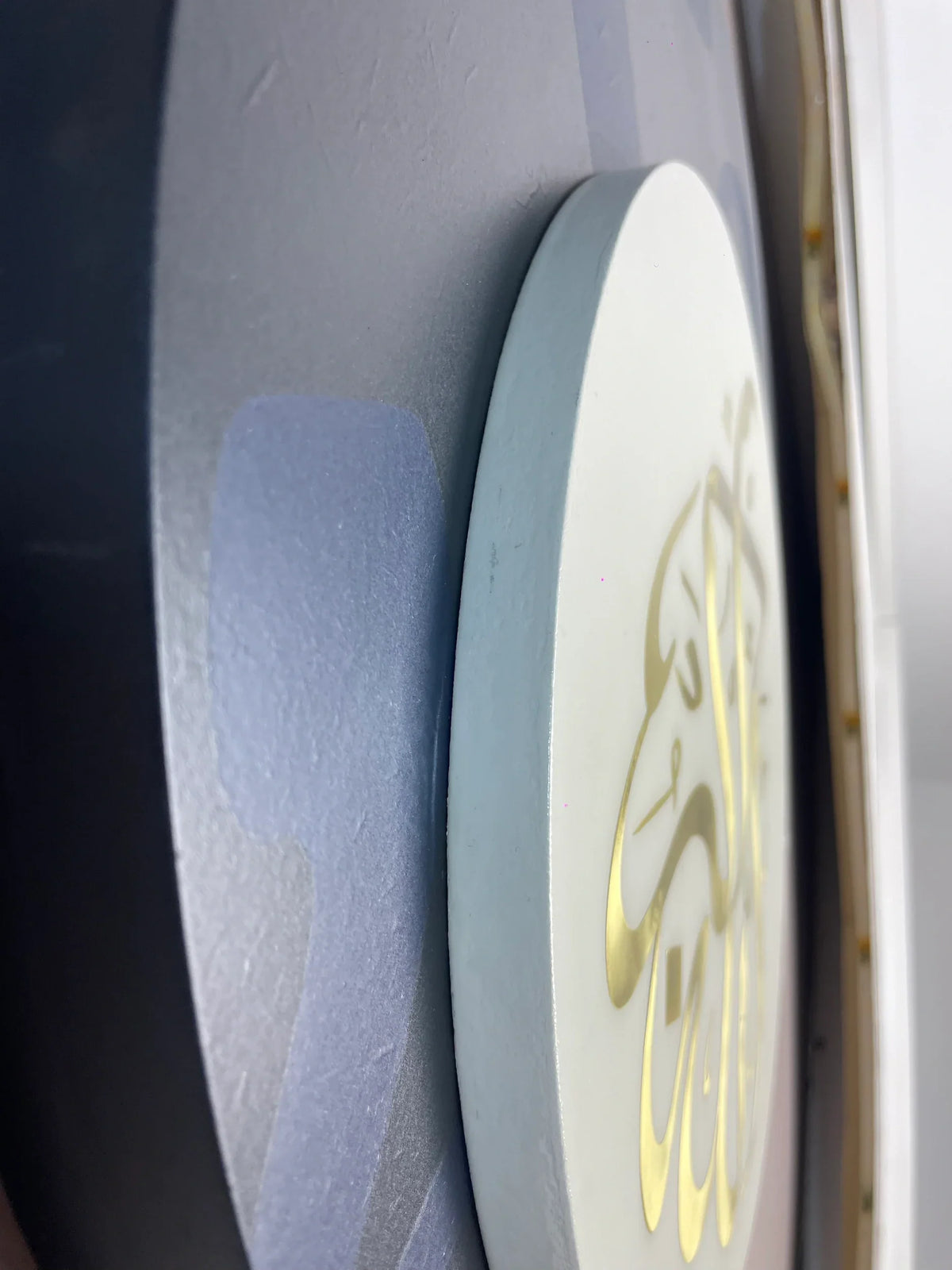 Vue réelle de profil de Wujud, épaisseur du disque clair et relief de la calligraphie